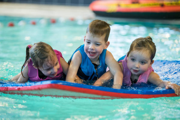 Kinderen liggen op een mat in het water