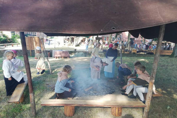 Kinderen zitten rond het kampvuur