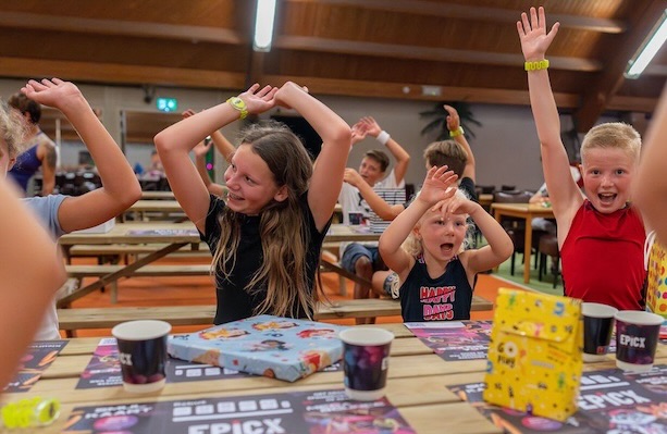 Kinderen lachen en zitten met hun armen in de lucht